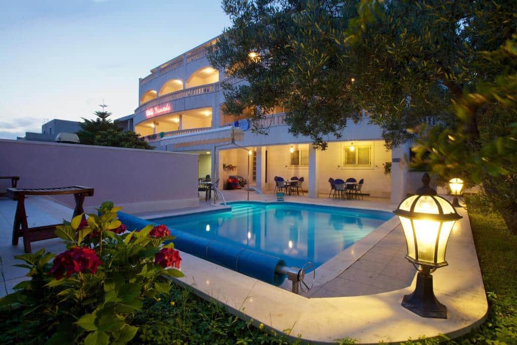 Hotel Villa Daniela na Ilha de Brac na. Vista externa do hotel com piscina ao entardecer