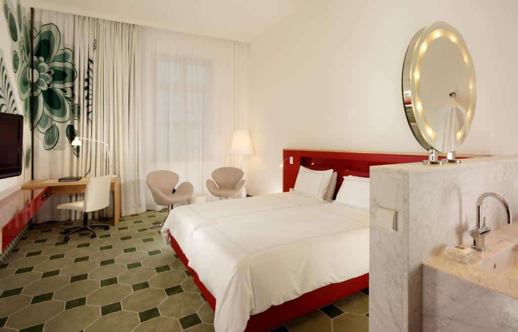 Hyperion Hotel Dresden Am Schloss - quarto do hotel, cama de casal com cabeceira vermelha e colcha branca e cortina em tons de branco e verde