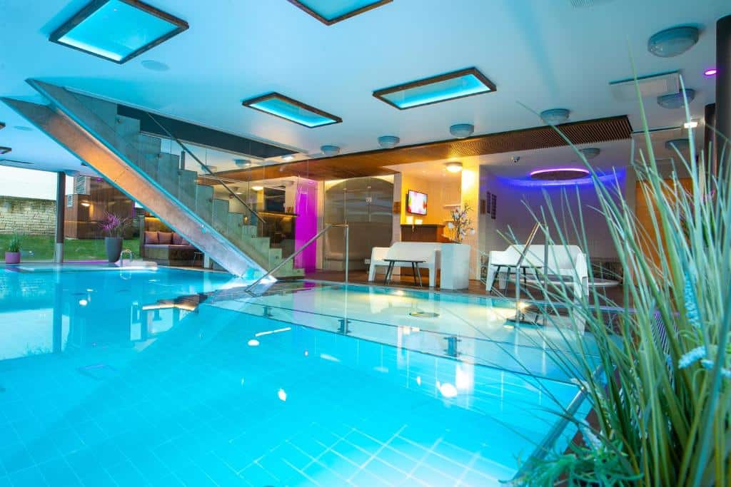 Spa do Johan Design & SPA Hotel - piscina coberta azul com escada e sofás brancos ao fundo.