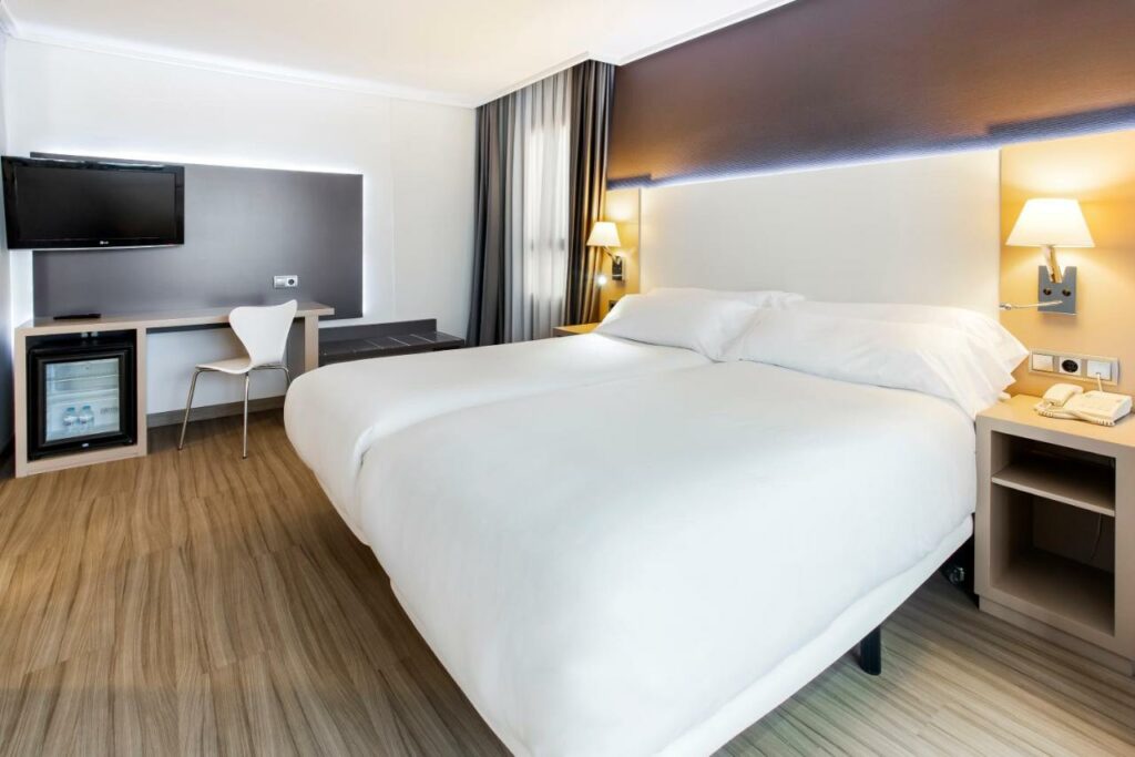 Quarto do hotel B&B HOTEL Cartagena Cartagonova na Costa Brava - duas camas de solteiro com roupa de cama brancas. Quartos em tons cinza e com madeira.