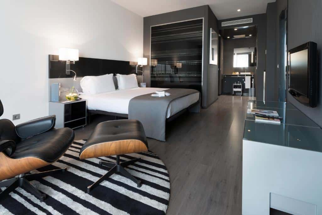 Quarto do hotel Eurostars Palace em Córdoba, quarto em tons de preto e branco com cama de casal e poltona