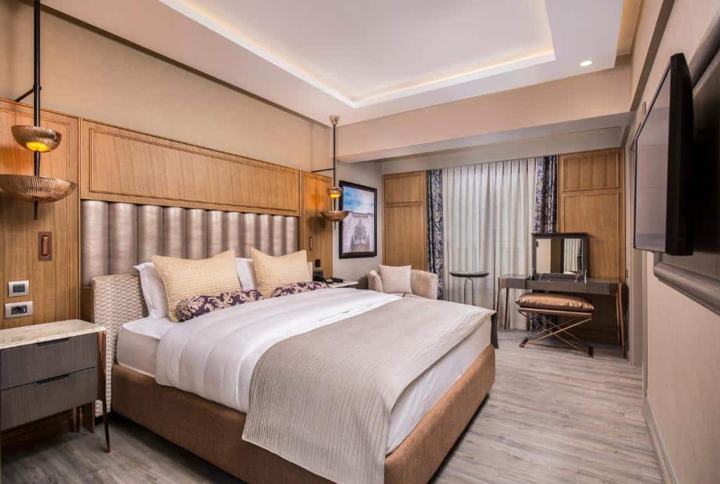 Quarto do Almira Hotel Thernal Spa em Bursa na Turquia - Quarto de casal com cama queen em tons de marrom, branco e cinza.
