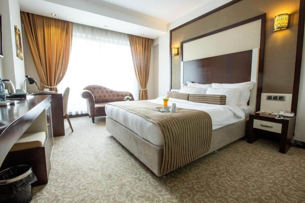 Quarto do hotel Lavin Hotel & Spa em Pamukkale, quarto em tons de bege, branco e marrom. Cama de casal com café da manhã sobre a cama
