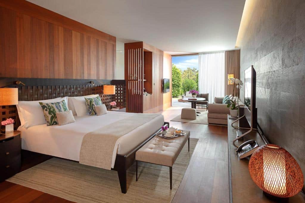 Quarto do hotel Mandarim Oriental em Bodrum na Turquia. Quarto em tons claros e madeira , cama de casal, com pequena sala e decoração moderna