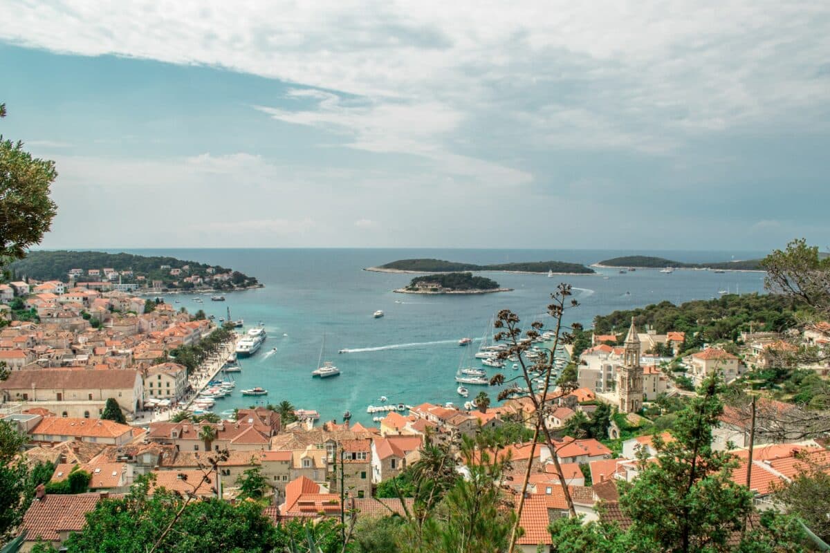 Ilha de Hvar na Croácia. Vista de cima da praia, mar azul esverdeado com lanchas e casas