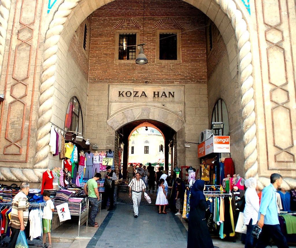 Entrada do mercado da Seda em Bursa - KOZA HAN com visitantes olhando os produtos a mostra.