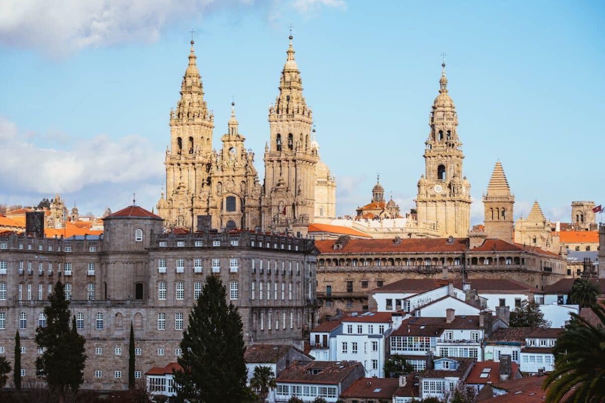 Vista do horizonte de Santiago de Compostela, com as torres ornamentadas da catedral e os edifícios históricos sob um céu azul, para representar Santiago de Compostela.