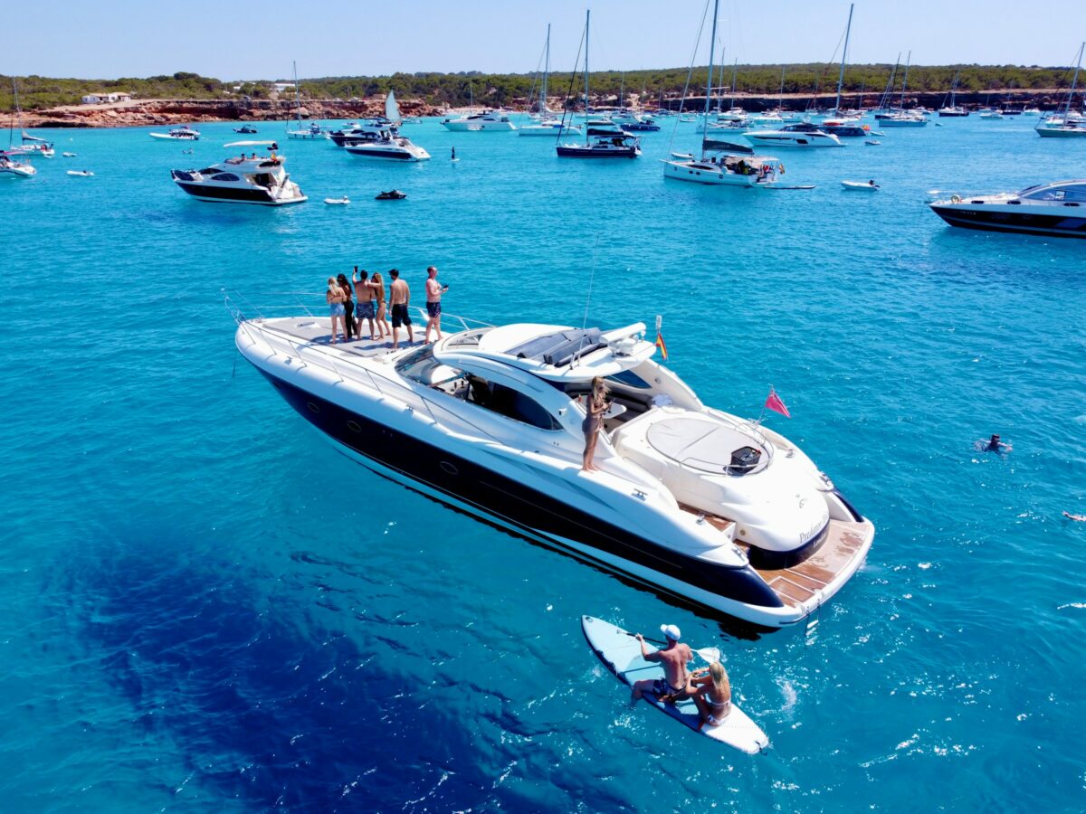 Foto de um barco com pessoas em uma mar azul turquesa em Ibiza